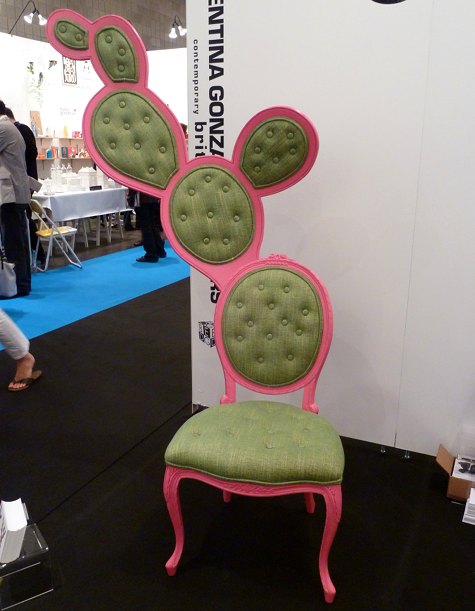 A photo of an ornate chair with a pink frame and green seating that looks like a prickly pear.