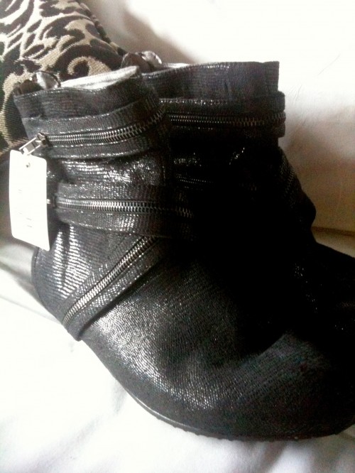 Photo of a pair of black sparkly boots adorned with superfluous zippers.