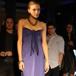 Model wearing a navy strapless dress with tie at bust.
