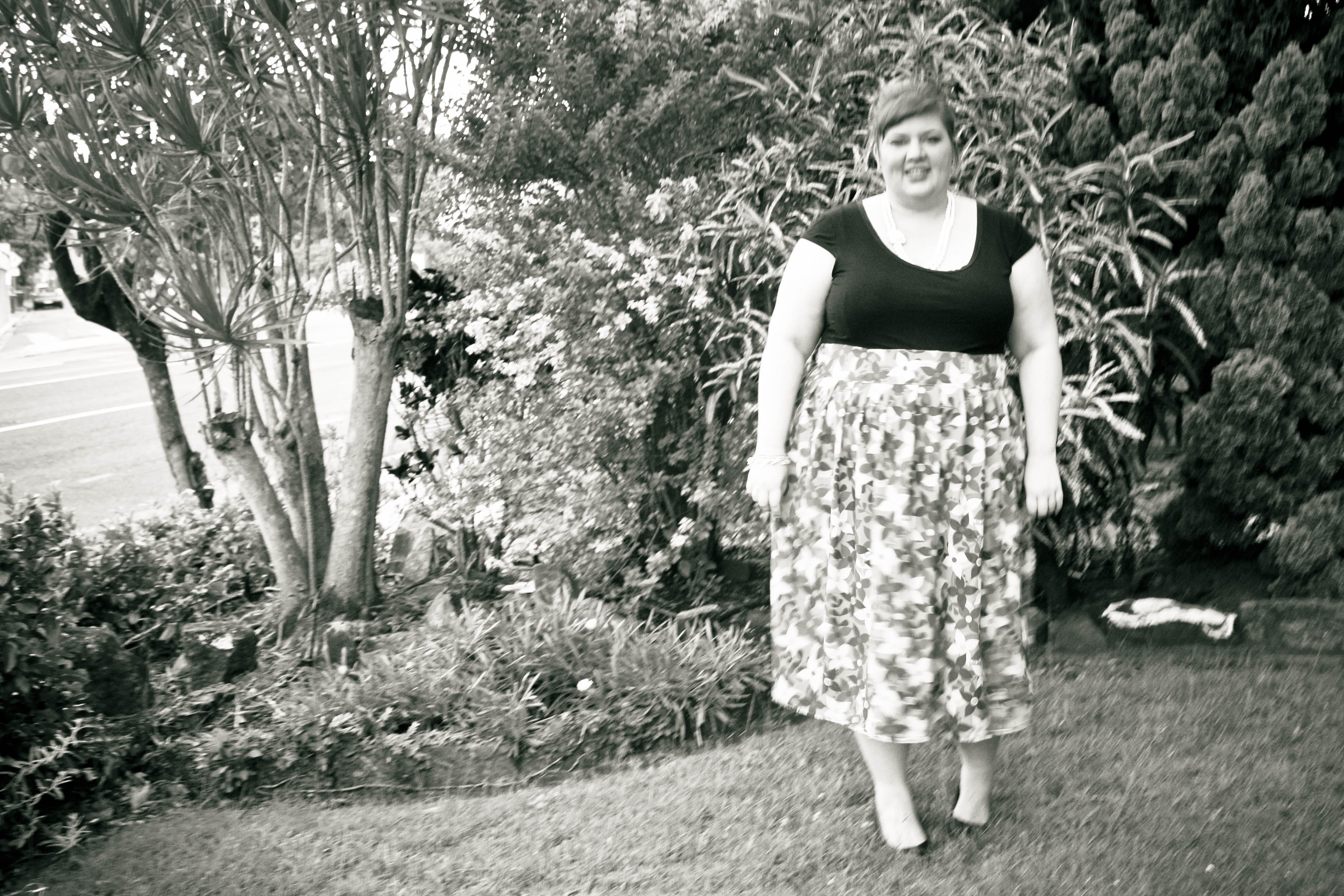 Black and white and slightly blurry photo of me in the garden.
