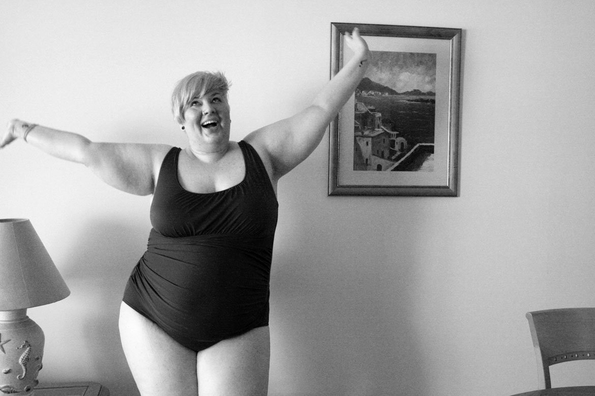 Black and white photo of me wearing a swim suit throwing my arms in the air.