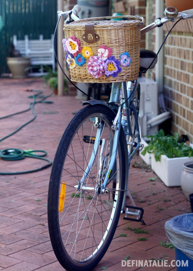 My ice blue bike with a wicker basket adorned with crocheted flowers.