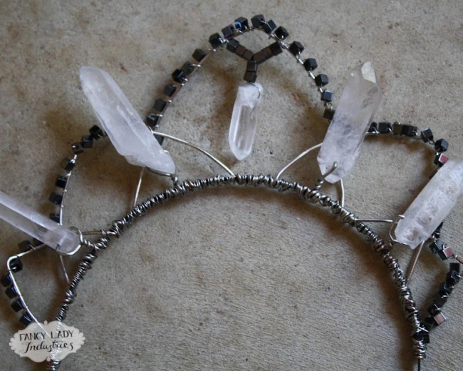 A tiara with five curved arcs, wrapped with small hematite cubes and accented with five crystal points. 