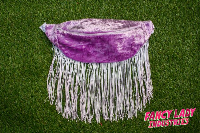 A vintage lilac velvet bumbag with long white fringing, available on Fancy Lady Industries.