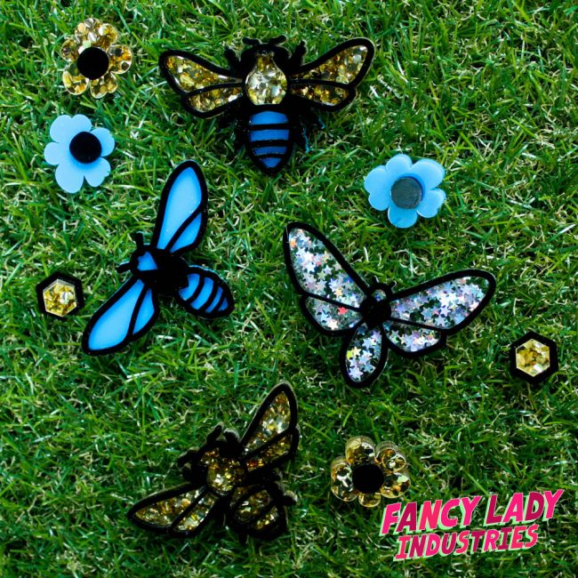 Laser cut moth, bee and wasp brooches amongst flower and honeycomb cell earrings, available on Fancy Lady Industries