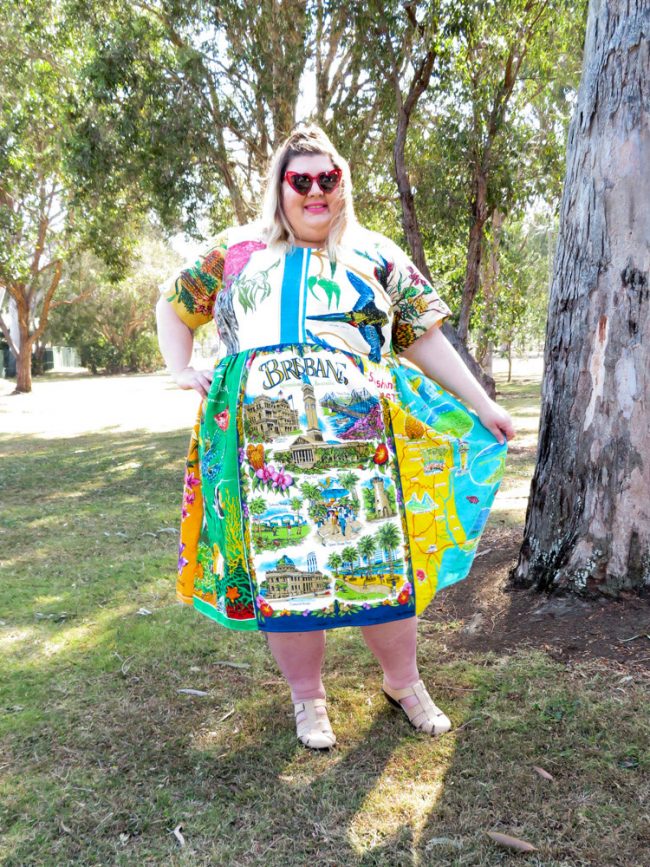 A photo of me holding the skirt of my dress out so you can see the Brisbane tea towel on the centre front more clearly.